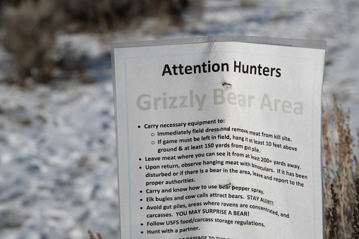 Bear warning posted in legal bison hunting area of north Yellowstone National Park near Gardiner, Montana USA.