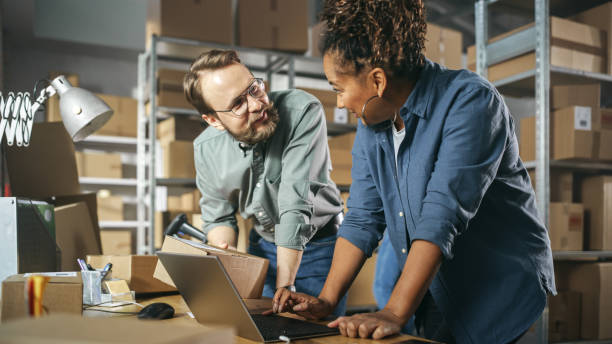 istock Happy Male and Female Working in Warehouse. Talking, Using Laptop Computer, Checking Retail Stock, Preparing Shipment. Successful Small Business Owners High Five Each Other. 1478423193