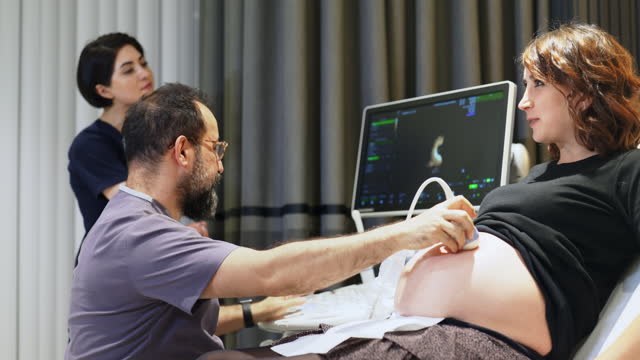 Gynecologist using ultrasound scanner while examining female patient with her family