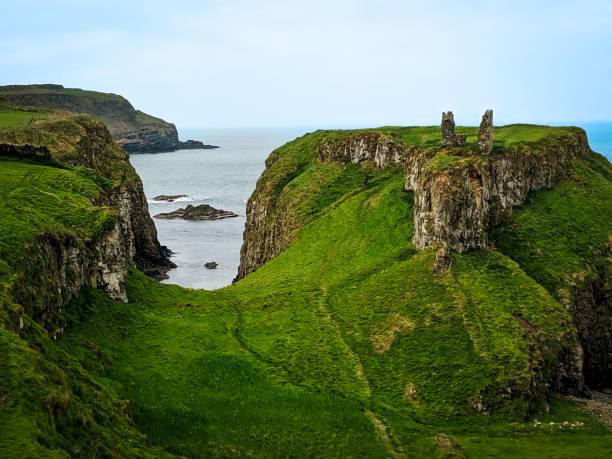 istock Dunseverick castle with green grass on rocky cliffs gloomy seascape background 1478430292