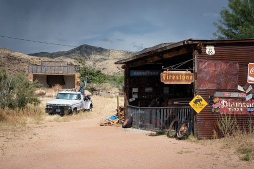 Arizona, United States – October 12, 2022: Old car mechanic shop on the desert road, there is a sixth generation Ford F-Series tow truck