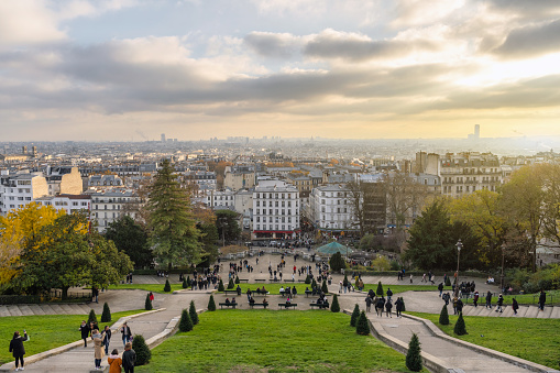 view down from the sacre coeur hill in monmartre quarter over paris skyline at sunset hour