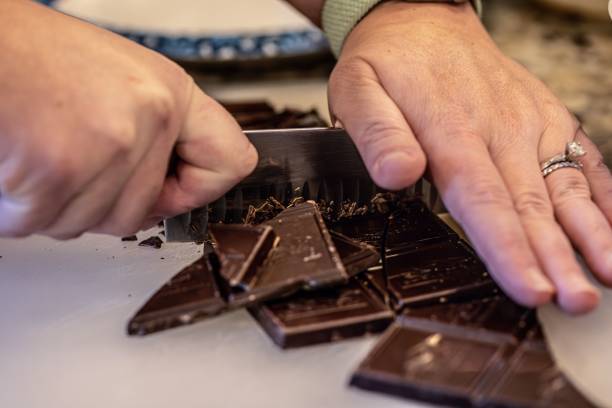 istock Closeup of a hand chopping chocolate bar into pieces 1478432887