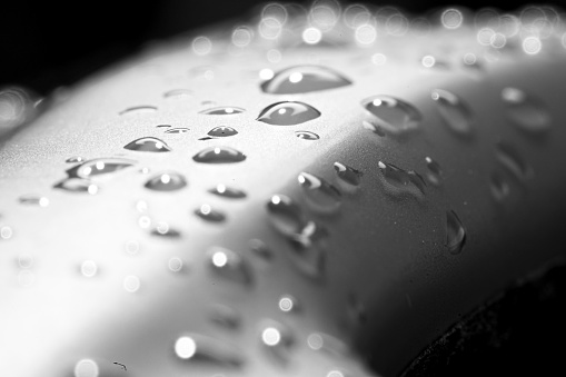 water droplets on Black metallic Paint. Black and white Image.