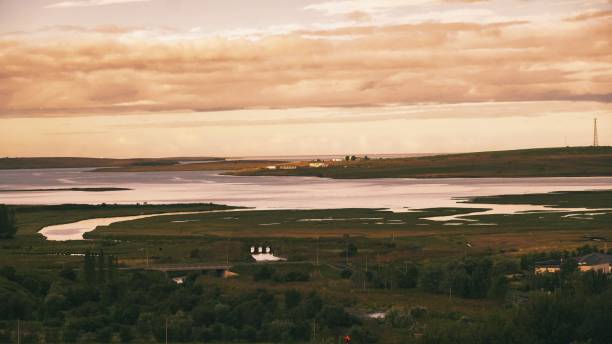 istock View of greenery before a lake under the cloudy orange sunset sky 1478436475
