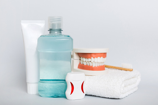 Mouthwash and other oral hygiene products on colored table top view with copy space. Flat lay. Dental hygiene. Oral care kit. Dentist concept.