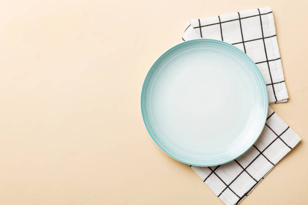 istock Top view on colored background empty round blue plate on tablecloth for food. Empty dish on napkin with space for your design 1478437021
