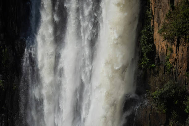 A strongly flowing waterfall plunges over a rocky cliff face.
