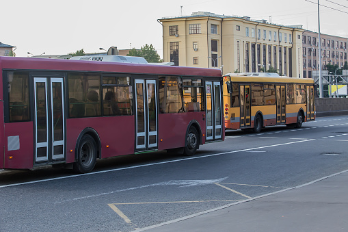 City buses move along the city street