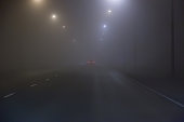 Car fog on road lit by lamps