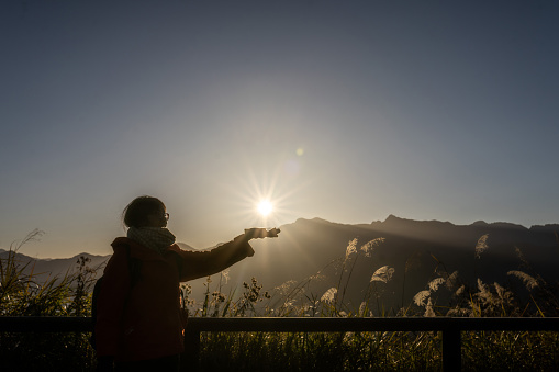 Woman holding the sun on her palm