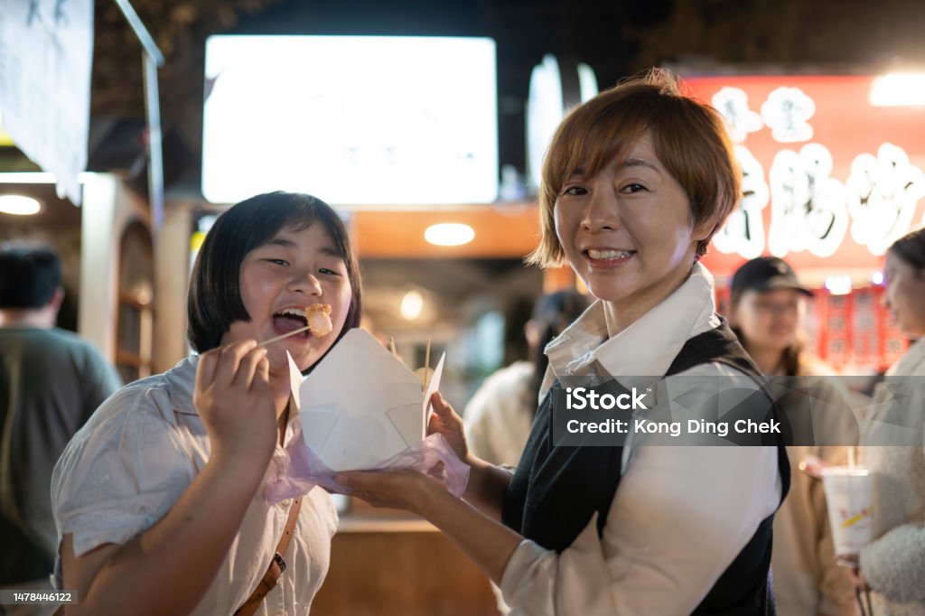 Asian Chinese family tourist discovery street food in night market Taiwan Night Market Stock Photo