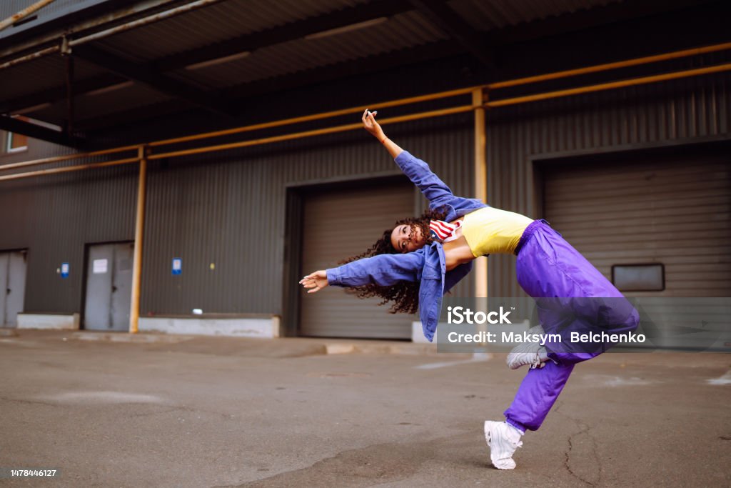Cool dancer on the street  with american bandana dancing. Cool dancer on the street in stylish clothes with american bandana dancing. young dancing woman showing some moves. 25-29 Years Stock Photo