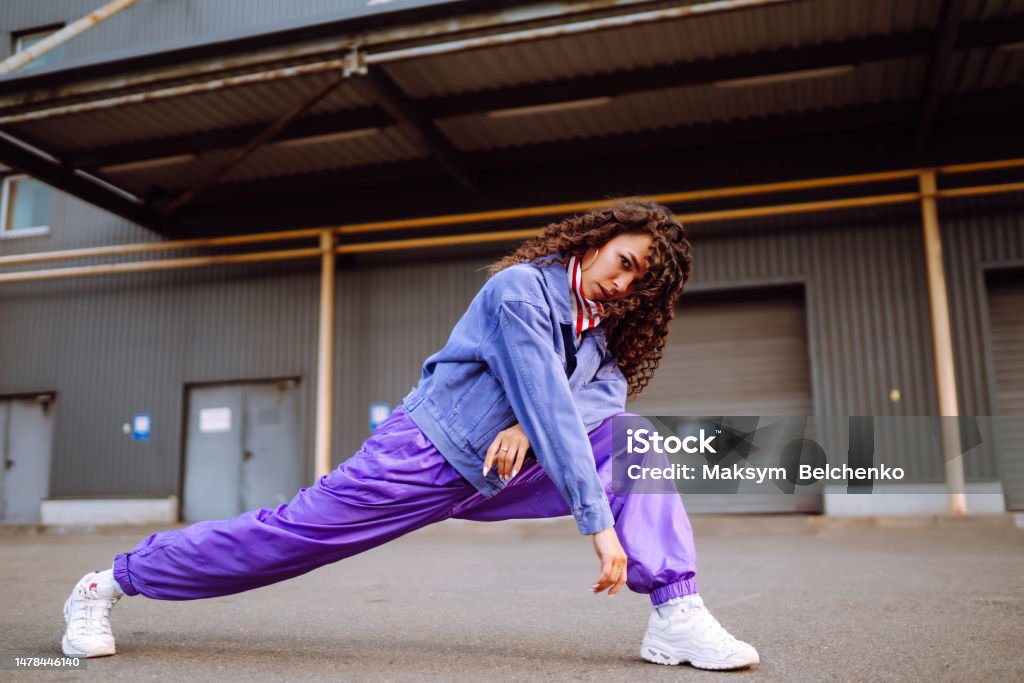 Cool dancer on the street  with american bandana dancing. Cool dancer on the street in stylish clothes with american bandana dancing. young dancing woman showing some moves. DJ Stock Photo