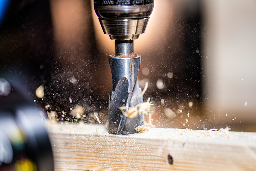 Close-up of drilling wood in workshop.