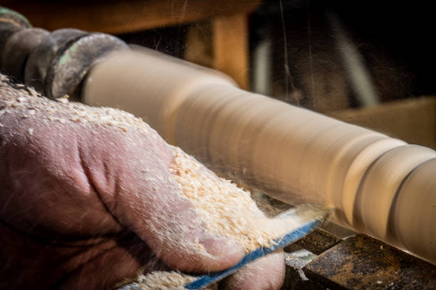 Close-up of man carpenter's hand craft wooden plank in workshop.