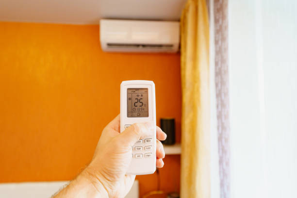 istock hand with the remote control of the air conditioner. 1478448069