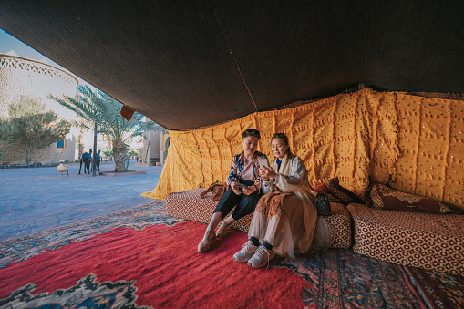 wide shoot 2 Chinese mature women relaxing in Bedouin tent camp in the desert Oasis