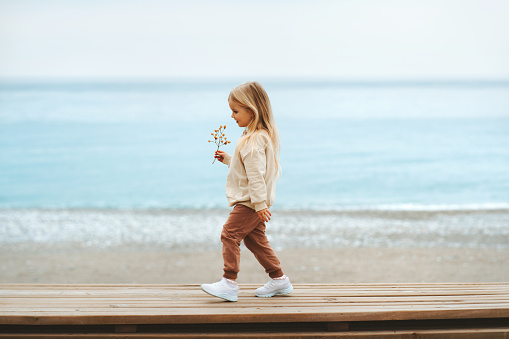 Child walking on the beach girl 4 years old family travel outdoor vacations trip