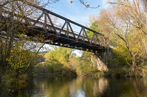 Old iron bridge over the river Eder with banks and trees in Hesse, Germany, Europe