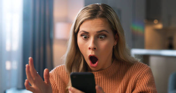 mujer sorprendida, cara o qué para estafa telefónica, correo electrónico de phishing o falla de seguridad en la sala de estar de la casa. wow, ansiedad o persona sorprendida en la tecnología de comunicación móvil con falla de hacker o robo cibernéti - frases de gente chismosa fotografías e imágenes de stock