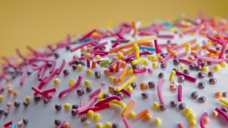 Easter cake decoration with colorful decorative sprinkles on yellow studio background. Homemade cake, christian festive bakery, tradition. Spring religious holiday