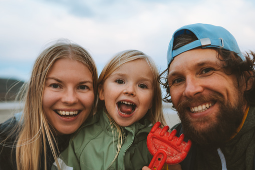 Family selfie parents with child outdoor mother and father with daughter happy smiling faces vacations lifestyle together