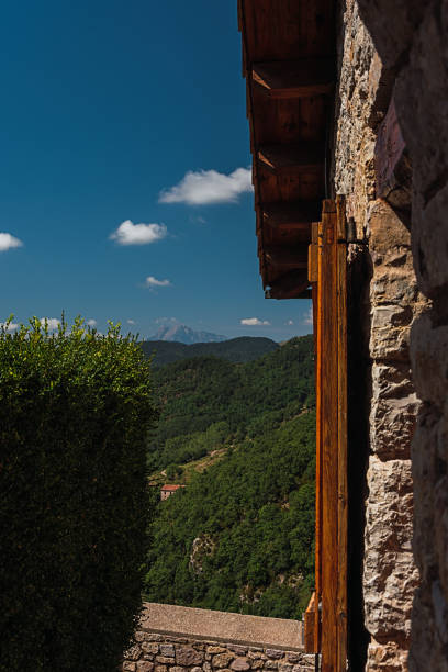 istock Vertical scenery of hills covered with forests captured from a stone house balcony 1478452935