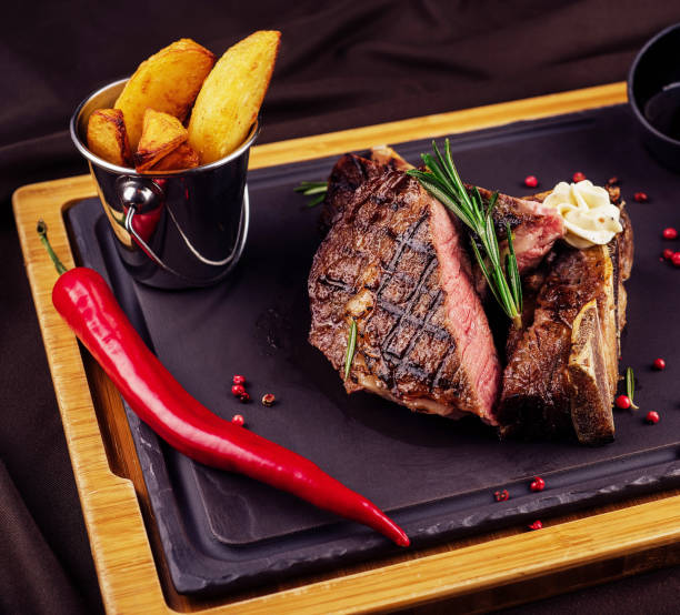 istock Grilled beef steak with rosemary, salt and pepper on cutting board 1478461941