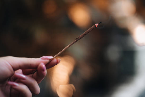 istock Female hand holding burning incense. Aromatherapy smoke. 1478463228