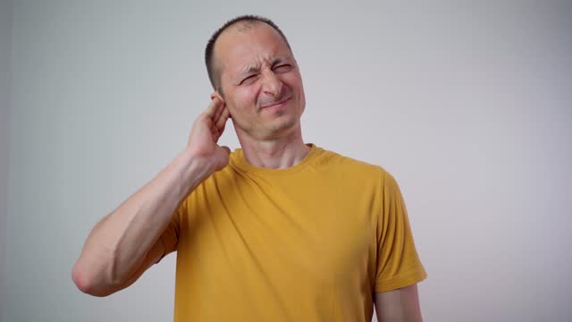 male having ear pain, touching his painful aching ear