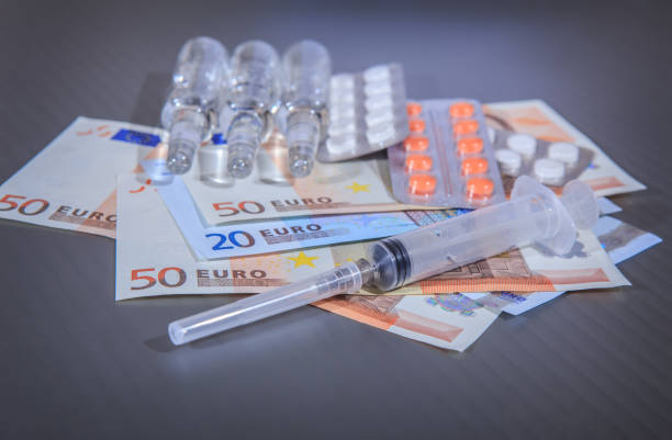 istock Medicines and a syringe on euro banknotes 1478470149