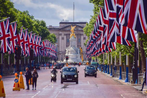 une vue du mall et de buckingham palace avec union jacks, londres, royaume-uni - palace buckingham palace london england famous place photos et images de collection