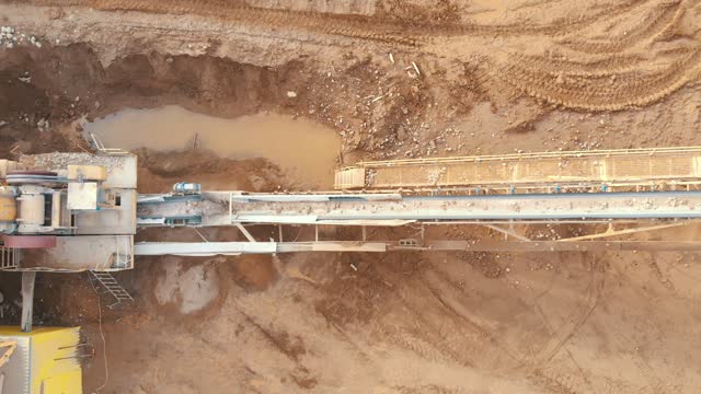 Jaw crusher plant with belt conveyor puts crushing stone and screening sand, aerial top view