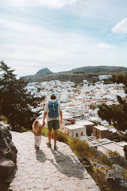 vacances en famille voyage en grèce père et enfant marche dans la ville de lindos visite d’été style de vie homme avec fille ensemble visiter l’île de rhodes - lindos photos et images de collection