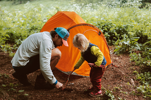 Father and daughter set camping tent travel family active vacations hiking gear outdoor adventure lifestyle backpacking trip in forest eco tourism