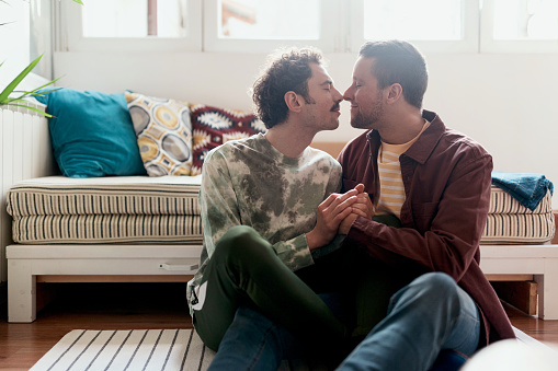 Two men kissing at home