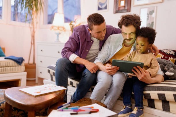 istock Gay couple looking at something on the tablet with their son 1478485514