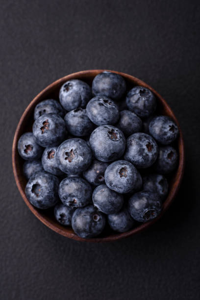 istock Delicious fresh blueberries on a textural black concrete background 1478503263