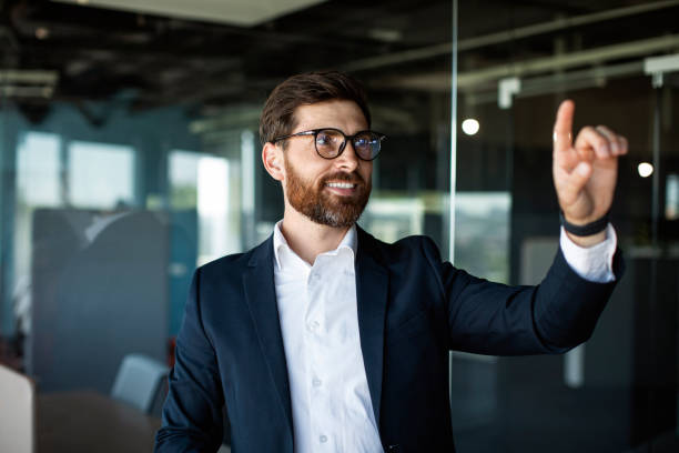 istock Middle aged male corporate manager in formalwear selecting something on virtual screen in office interior, mockup 1478504367