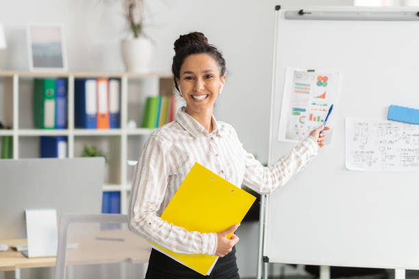 istock Cheerful female manager having video call, giving virtual presentation and showing graphs and diagrams on whiteboard 1478504511