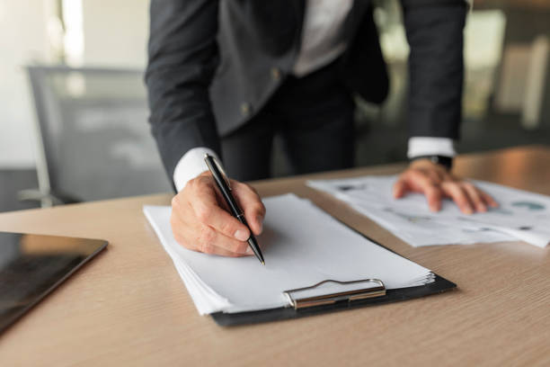 istock Male entrepreneur signing contract, putting signature on official documents, selective focus on clipboard with papers 1478505416
