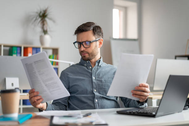 istock Focused mature engineer businessman in glasses working with documents, sitting at workplace in office interior 1478505680