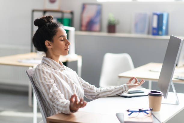 istock Coping with stress at work. Young latin office worker meditating at workplace in office after busy day 1478505997