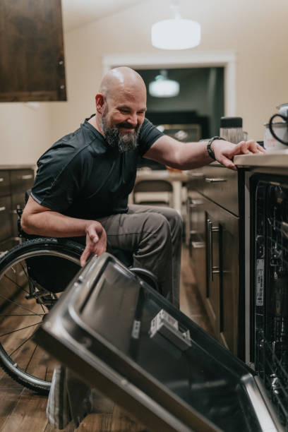 istock Man in wheelchair at home cleaning the kitchen 1478508096