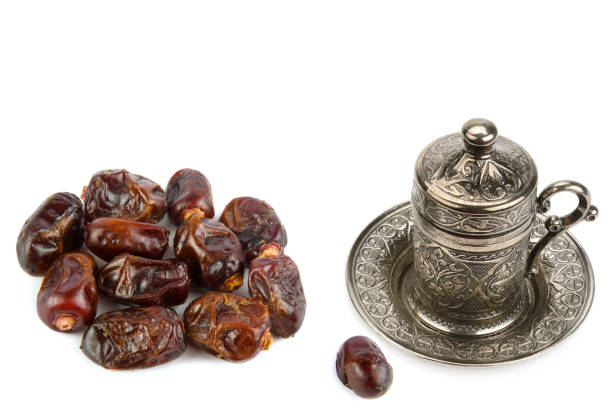 istock Dried dates and tea in a beautiful cup isolated on white. Collage. Free space for text. 1478509370