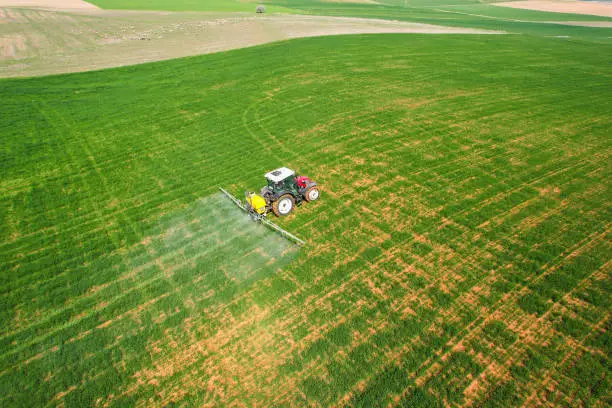 Photo of Spraying with a red tractor in Eskişehir agricultural lands, aerial shot