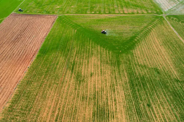 Photo of spraying agricultural lands with a red tractor aerial shot