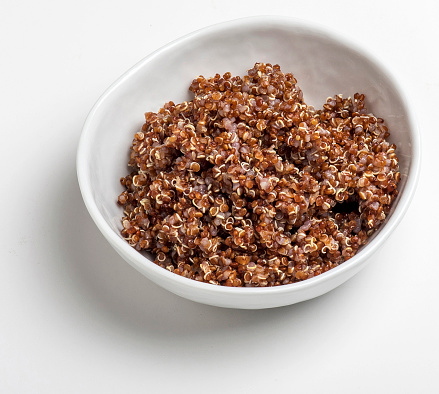 Red quinoa in a white porcelain bowl.