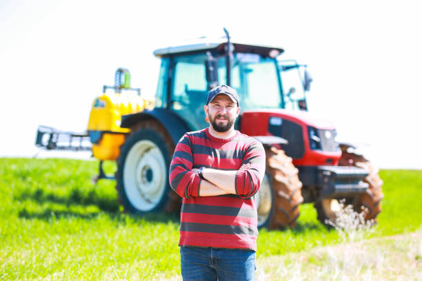 istock young farmer with arms folded in front of red tractor 1478533899